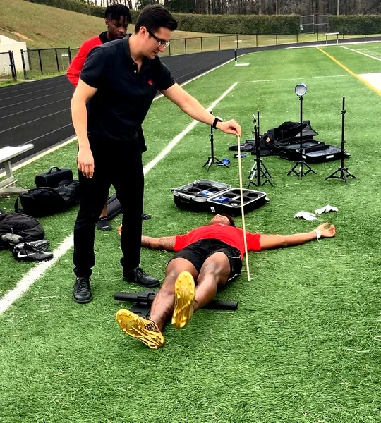 Lockerroom staff measuring an athlete's broad jump distance